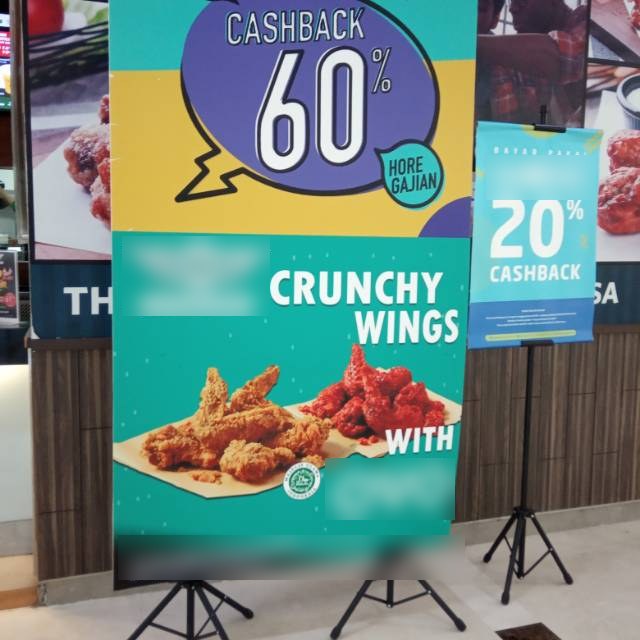 In-store promo banner showing the cashback percentage, with brand names blurred